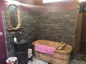 a bathroom with a wooden tub and a stone wall at Mas de Bouilhac in Pranles