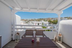 a porch with two chairs and a table on a balcony at Beautiful Apartment With Amazing View, In Mykonos Old Town in Mýkonos City