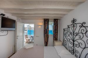 1 dormitorio con 1 cama y TV en la pared en Beautiful Apartment With Amazing View, In Mykonos Old Town, en Mykonos ciudad