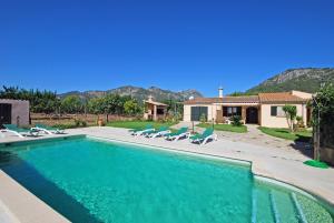 uma piscina com espreguiçadeiras e uma casa em Villa Tabou em Selva