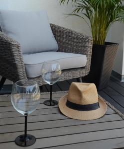 two wine glasses and a hat on a patio at Villa Corleone in Kąty Wrocławskie