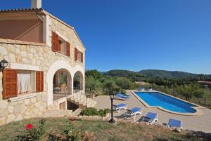 ein Gebäude mit einem Pool neben einem Haus in der Unterkunft Villa Rotes in Campanet