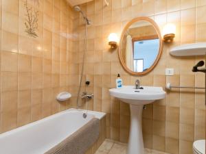 łazienka z umywalką, wanną i lustrem w obiekcie Villa joy w Playa de Muro