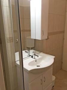 y baño con lavabo blanco y espejo. en Balatonfenyves - Munkácsy u. 6. en Balatonfenyves