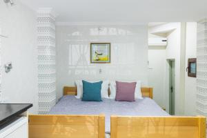 - une chambre avec un lit et des oreillers colorés dans l'établissement HB apartments Akhvelediani II, à Tbilissi
