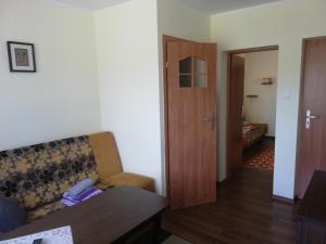 a living room with a couch and a door to a bedroom at Pokoje Gościnne Słoneczko in Kąty Rybackie