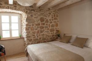 ein Schlafzimmer mit einem großen Bett in einer Steinmauer in der Unterkunft Sobe Bile in Pag