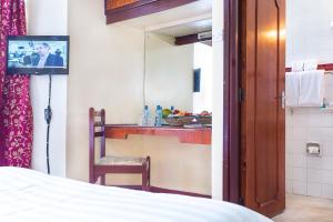 um quarto com uma cama e uma televisão num quarto em Methodist Resort em Nairobi