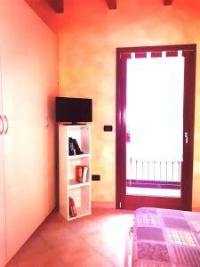 een slaapkamer met een bed, een tv en een raam bij APPARTAMENTO INDIPENDENTE IN VILLETTA IN BIOARCHITETTURA in Gemmano
