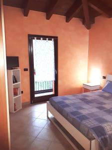 een slaapkamer met een bed en een raam bij APPARTAMENTO INDIPENDENTE IN VILLETTA IN BIOARCHITETTURA in Gemmano