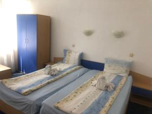 Dos camas en una habitación de hospital con toallas. en Guest House Rai en Kiten