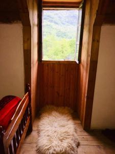 a bedroom with a window and a furry rug in a room at Guesthouse Dritan Tethorja in Theth