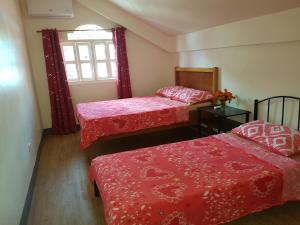 a room with two beds and a window at OMG Guesthouse Room for 3 pax in Licup