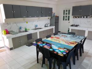 a kitchen with a table and chairs and a kitchen with a counter at OMG Guesthouse Room for 3 pax in Licup