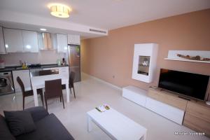 een woonkamer met een bank en een tafel en een keuken bij Alegria1 in Torrevieja
