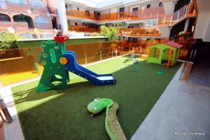 een kamer met een speeltuin met een glijbaan en een speelplaats bij Alegria1 in Torrevieja