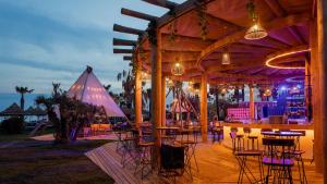 a bar with tables and chairs at night at Titanic Mardan Palace in Lara +68 photos