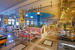 a restaurant with tables and chairs and chandeliers at Mardan Palace in Lara +36 photos