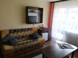 a living room with a couch and a table at Pokoje Gościnne Słoneczko in Kąty Rybackie