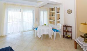 a white dining room with a table and chairs at Analipsi House Afrodite in Kástro Tornéze