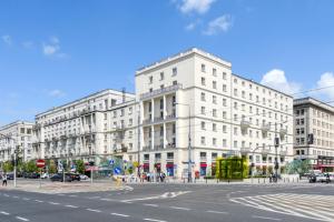 ein großes weißes Gebäude in einer Stadtstraße in der Unterkunft ClickTheFlat Palace of Culture View - Apart Rooms in Warschau