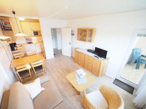 ein Wohnzimmer mit einem Tisch und einer Küche in der Unterkunft Appartement 89 in Westerland