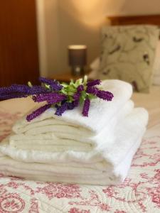 a stack of towels with purple flowers on a bed at But & Ben in Balloch in Balloch
