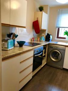 a kitchen with a stove and a washing machine at But & Ben in Balloch in Balloch