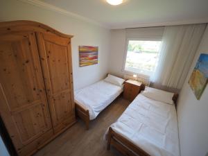 ein kleines Schlafzimmer mit 2 Betten und einem Fenster in der Unterkunft Appartement 89 in Westerland