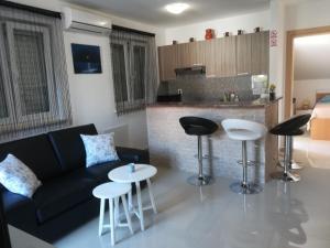 a living room with a couch and some bar stools at Apartment Ivana in Punat
