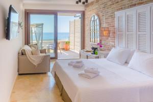 a bedroom with a large white bed with a view of the ocean at Agorastos Hotel in Koinyra