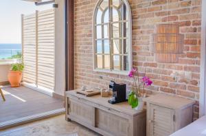 a room with a brick wall and a window and a desk at Agorastos Hotel in Koinyra