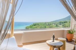 a room with a table and a view of the ocean at Agorastos Hotel in Koinyra