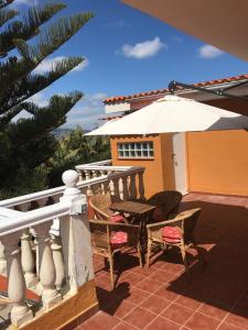 une terrasse avec une table et un parasol dans l'établissement APARTAMENTO EN LA LAGUNA, à La Laguna