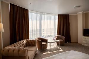 uma sala de estar com um sofá e cadeiras e uma grande janela em AZIMUT Hotel Penza em Penza