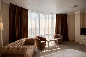 a living room with a couch and chairs and a large window at AZIMUT Hotel Penza in Penza