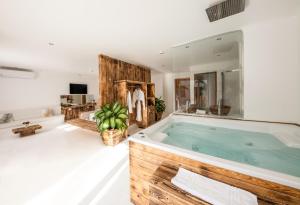 a large bathroom with a large wooden tub at Meraki Resort - Adults Only in Hurghada