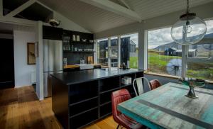 a kitchen with a table and a large window at Hvammsvík Nature Resort in Kjósahreppur