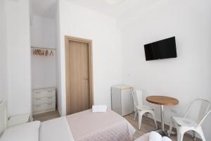 a bedroom with a bed and a table and chairs at Lovely Studios In Mykonos Old Town in Mýkonos City