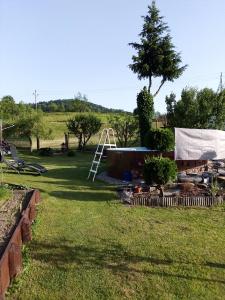 a playground in a yard with a tree and a ladder at u Vlastika in Jeseník