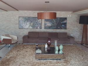 una sala de estar con un sofá y una mesa en Scopa Beach - apartamento no Porto das Dunas - vizinho ao Beach Park, en Aquiraz