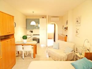 eine Küche und ein Wohnzimmer mit einem Tisch und einem Sofa in der Unterkunft Casa Vacanze Stelle Marine in Santo Stefano al Mare