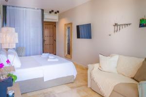 a bedroom with a white bed and a couch at Agorastos Hotel in Koinyra