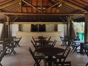 Un comedor vacío con mesas y sillas. en Scopa Beach - apartamento no Porto das Dunas - vizinho ao Beach Park, en Aquiraz