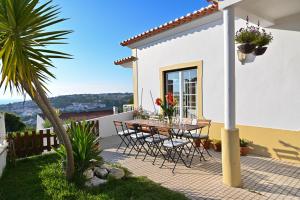 une terrasse avec une table et des chaises dans une maison dans l'établissement Coworksurf - Villa dos Irmãos, à Ericeira