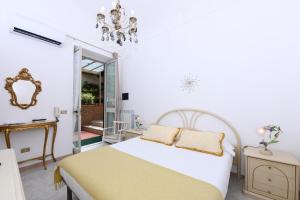 een witte slaapkamer met een bed en een spiegel bij A Passo Duomo in Amalfi