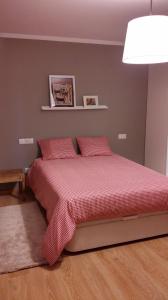 um quarto com uma cama com lençóis vermelhos e um candeeiro em Apartamento con piscina en Foz em Foz