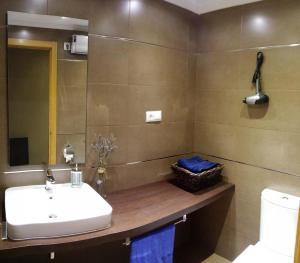 uma casa de banho com um lavatório e um WC em Apartamento con piscina en Foz em Foz