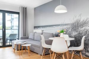 salon z kanapą, stołem i krzesłami w obiekcie Apartamenty Gardenia Seaside by Noclegi Renters w Dziwnowie +37 zdjęć