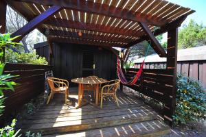 a wooden pergola with a table and chairs on a deck at Résidence Mobydick in Porto-Vecchio